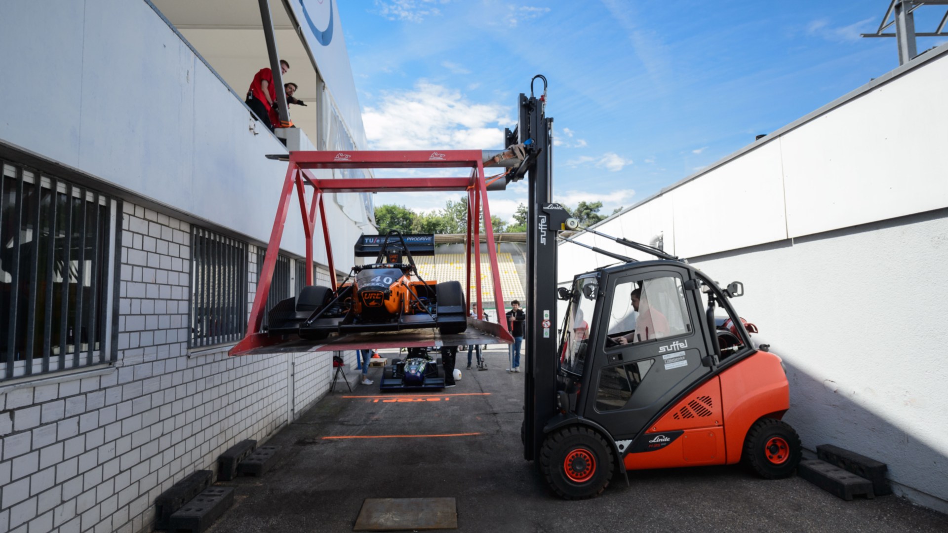 Una carretilla de alquiler de Linde transporta cuidadosamente un monoplaza de competición